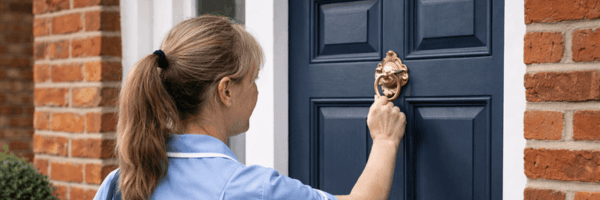 Professional care worker visiting person's home, representing domiciliary care services that use Vera for medication monitoring between visits